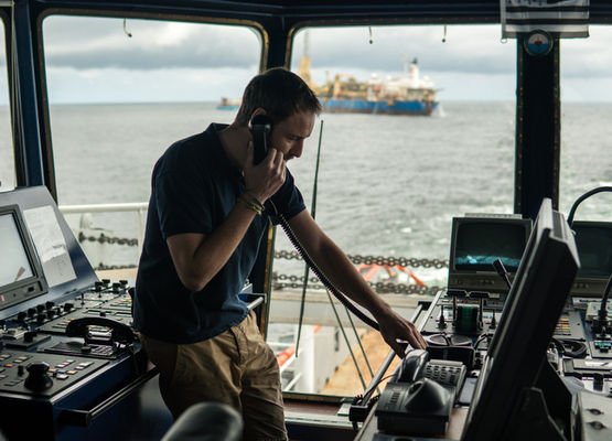 Boat captain on boat while on phone and navigating