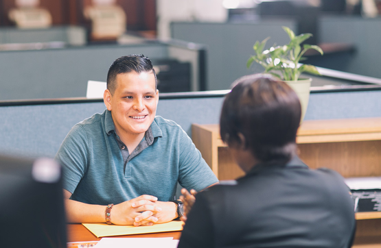 Woman helping young man in an office setting